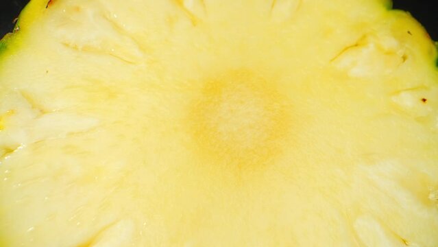 Intriguing macro video with a probe lens capturing the vibrant essence of a juicy Pineapple Slice. Its golden hues glisten, intricate textures reveal, and succulent sweetness beckons. Pineapple backgr