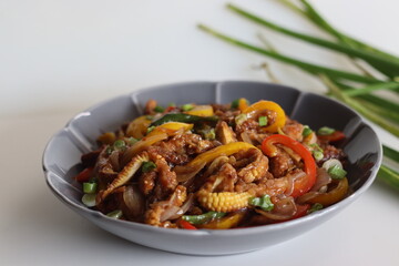 Baby corn chilly. An Indo Chinese dish with crisp fried baby corn in a spicy sauce with sauteed onions and bell peppers.