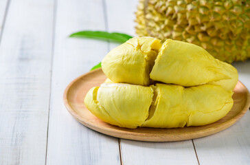 Durian fruit. Ripe monthong durian on wood plate and white wood background, king of fruit from Thailand