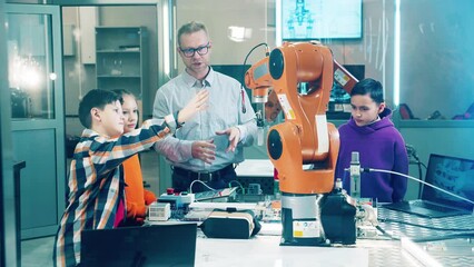 School teacher with students work with robot in a school lab