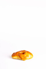 fresh bun with dried apricots on a white photo.