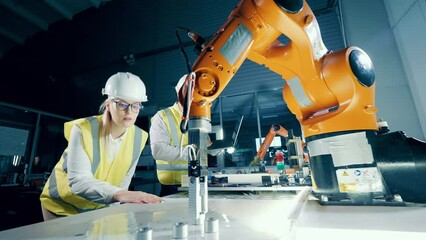 Robotics engineers in hardhats are studying robots