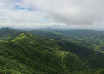 Panoramic landscape view of beautiful lush green Sahyadri mountains in monsoon season as seen from Sinhgad fort located in Pune, Maharashtra, India