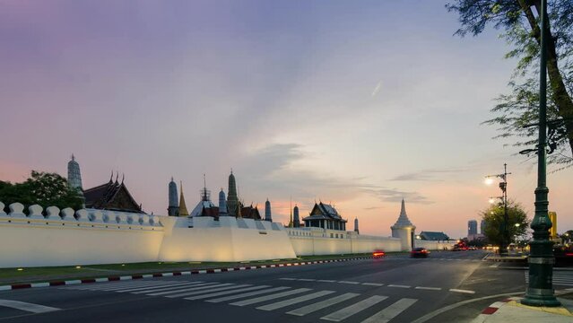 timelapse street view at grand royal palace of Bangkok with many traffic in long expossure light tail technique in sunset with beautiful vanila skytime.