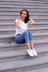 Woman is sitting on the stairs outdoors