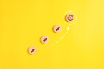 Target goal and arrow up icons on wooden blocks for business strategy planning and quality...