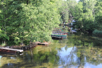 Fototapeta na wymiar Beautiful summer landscape with river and wooden boats in the forest in summer