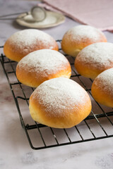 Sweet round buns with icing sugar on top on cake cooling rack. Typical sweet from Majorca, Spain