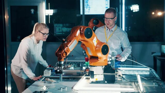 Robotics technicians are examining robotic devices in a modern lab