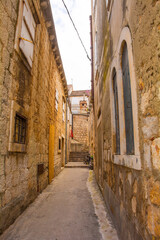 A street of historic stone houses in Milna Village on the west coast of Brac Island in Croatia. Some of the doors are filled in or boarded up