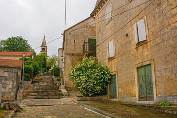 An historic residential street in the town of Nerezisca on Brac Island in Croatia. The Church of Our Lady of Mount Carmel  is in the background