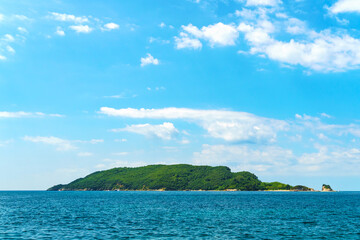 Fototapeta premium an island in the distance in the sea, blue sky with clouds, beautiful scenery in Montenegro, Adriatic Sea, tourism and travel