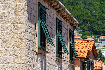 street view of the old town of Dubrovnik in Croatia, medieval European architecture, city streets, windows with wooden shutters, red tiled roofs, the concept of traveling in the Balkans
