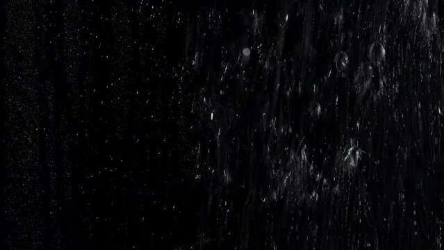 Water running on a misted surface with a black background