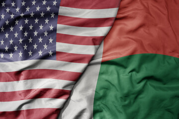 big waving colorful flag of united states of america and national flag of madagascar .