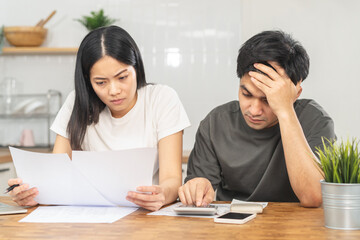 Stressed couple family, wife and husband confused, hand use calculator calculate expense from invoice, have no money to pay. Mortgage, loan causing debt, bankruptcy. Debt problems, Financial people.