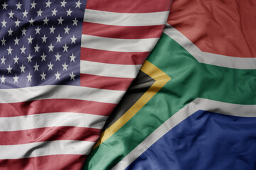 Obraz premium big waving colorful flag of united states of america and national flag of south africa .