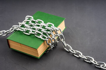 a large green book chained on a gray background