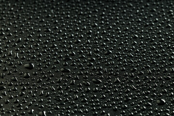 a lot of water droplets are randomly arranged on a black background