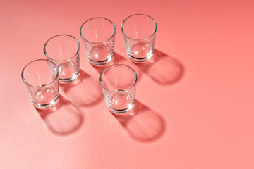 five glass glasses for alcohol on the surface. shadows from glasses