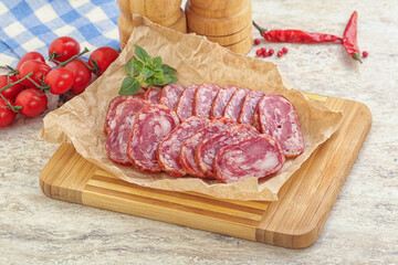 Sliced salami sausages over board