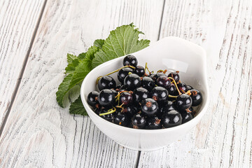 Juicy black currant berries in the bowl