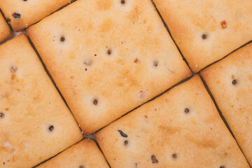 Delicious spicy square crackers closeup. Macro shot.