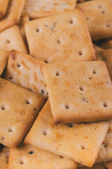 Heap of delicious spicy square crackers. Salty crackers closeup. Macro shot. Selective focus.