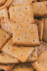 Heap of delicious spicy square crackers. Salty crackers closeup. Macro shot. Selective focus.