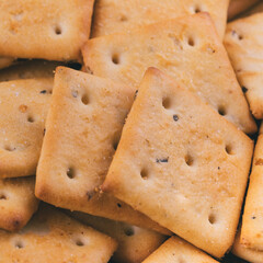 Heap of delicious spicy square crackers. Salty crackers closeup. Macro shot. Selective focus.