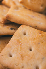 Heap of delicious spicy square crackers. Salty crackers closeup. Macro shot. Selective focus.