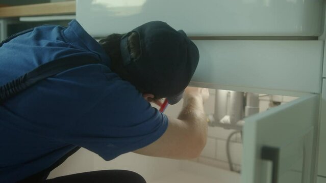 Master Plumber Conducts Expert Repair Work Underneath Lavatory at Home