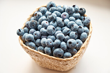 A basket of fresh blueberries, on a white background. Berries, healthy food. Side view.