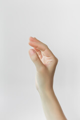 female hand holding something invisible on gray background