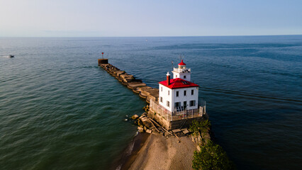 Lighthouse Looking Out Over the Water at Sunset Aerial
