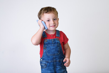 Smiling boy using cell phone isolated in white studio