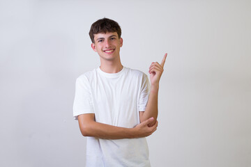 young caucasian man over isolated white background smiling cheerfully pointing index finger away