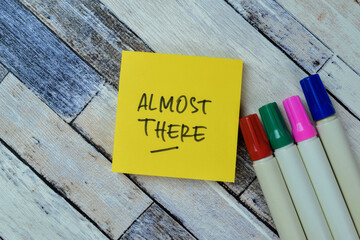Concept of Almost There write on sticky notes isolated on Wooden Table.