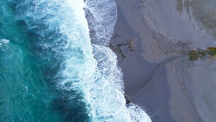 Aerial photo of a desolate stretch of sandy beach during tumultuous storm waves relentlessly pounding the shore Crazy beauty turquoise foamy wave