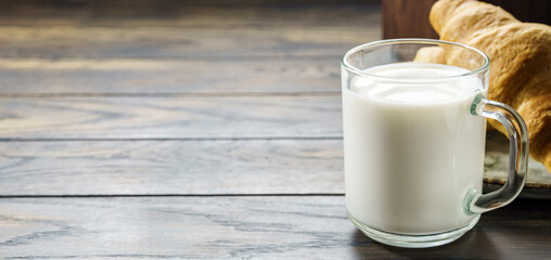Glass of milk with a croissant with copy space
