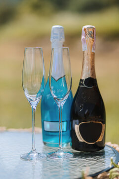 champagne bottles and glasses next to each other on the table. Blue and black champagne