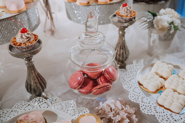 Festive dessert table with sweets. Wedding candy bar, various cakes, chocolates on stands.