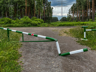 Damaged barrier on the road, limiting the entry of vehicles into the forest.