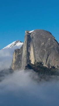 Aerial Yosemite National Park Cloudscape. Iconic Half Dome revealed as low clouds open up. Vertical design in 9:16 ratio. Smartphone and social media ready.