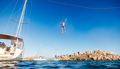 Man falling from zipline mounted on mast of boat