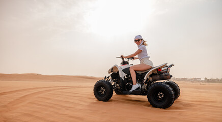 Woman riding sand dunes ATV in the Dubai desert - 626394436