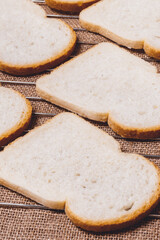 Sliced white bread on grill grid with sackcloth under it.