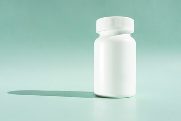 White Bottle Of Medication Pills Or Vitamins On Green Or Turquoise, Mint Background With Shadow. Horizontal Plane. Copy Space For Text. Healthy Bio Supplements. Pharmacology. Design Or Mockup