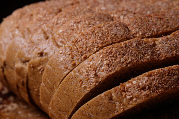 Sliced brown bread covered with bran closeup. Macro shot.
