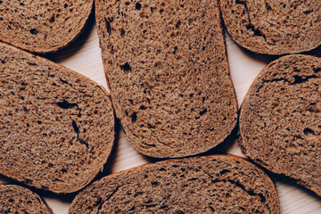 Sliced brown bread on the white wooden table. Top view